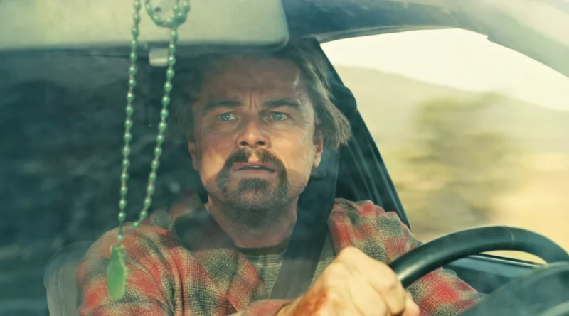 Primer plano de Leonardo DiCaprio como Bob Ferguson conduciendo un coche en una escena de la película Una batalla tras otra.